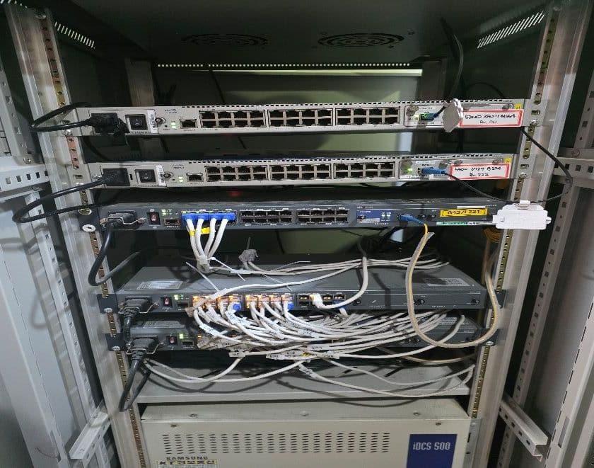 공사 전 장비함 내부 — 스위치와 묶이지 않은 흰 랜선, 아래 칸에 전화 교환기