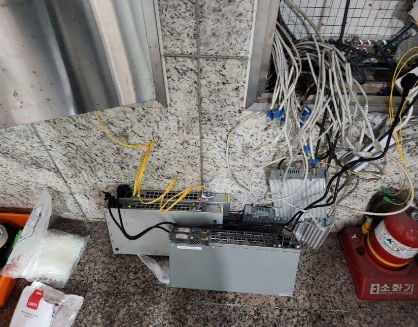 공사 전 복도 벽 통신함 아래 바닥에 놓인 장비와 늘어진 선
